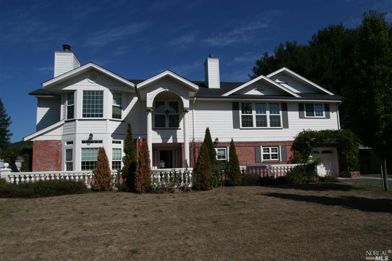 a front view of a house with yard and green space