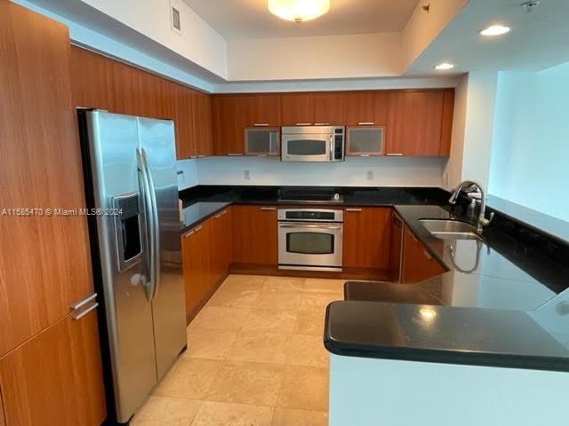 a kitchen with stainless steel appliances granite countertop a sink a stove and a refrigerator