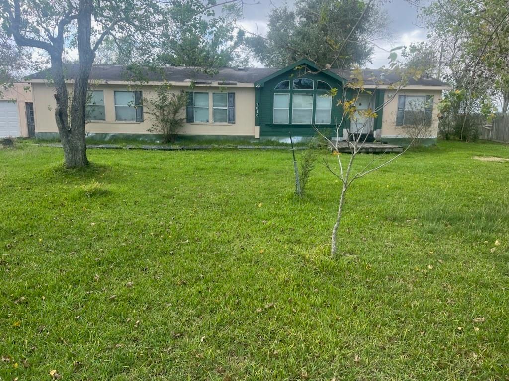 a view of a house with a yard and sitting area