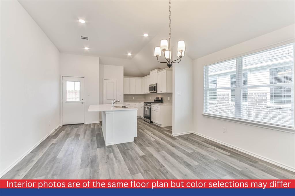 a view of a kitchen with kitchen island wooden floor center island and stainless steel appliances