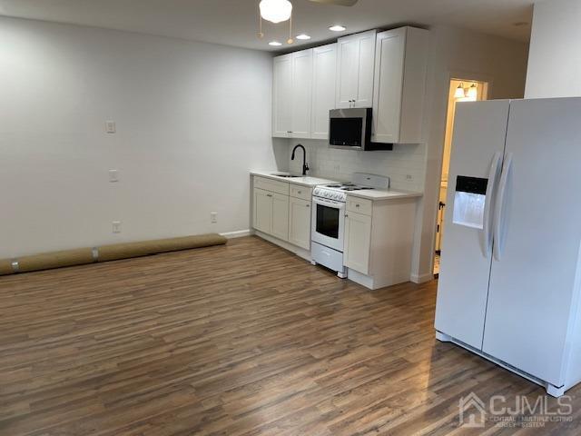 a large white kitchen with a sink a stove and a refrigerator