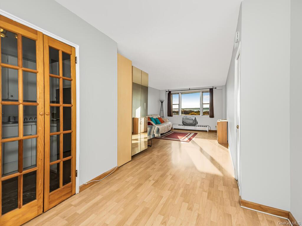 Hallway featuring light wood-type flooring and a baseboard radiator