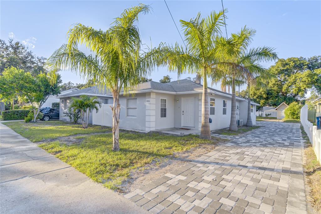 a view of a house with a yard and palm trees