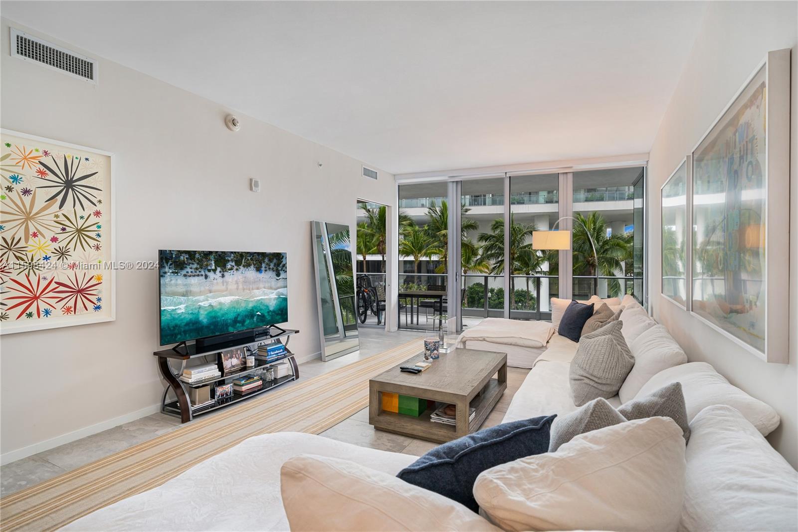 a living room with furniture tv and a floor to ceiling window