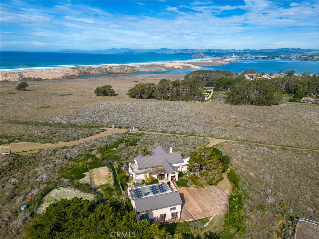 an aerial view of ocean and residential houses with outdoor space