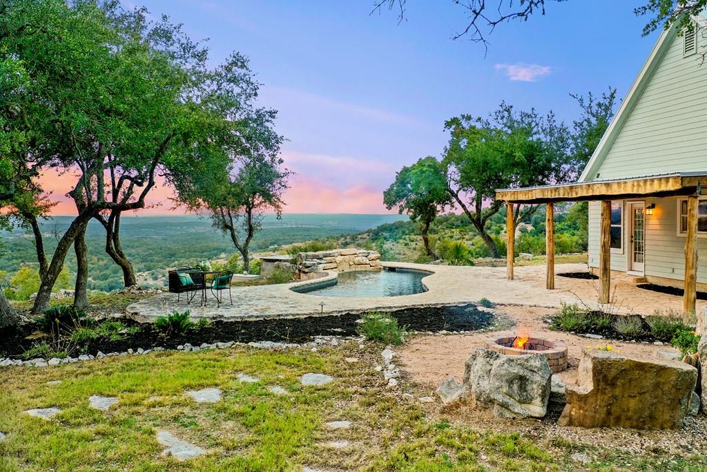 a view of a swimming pool with a patio and a yard