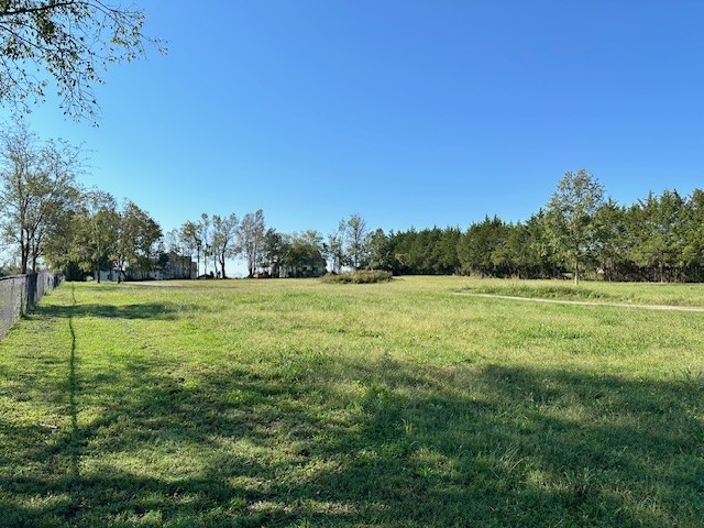 a view of a green field with wooden fence