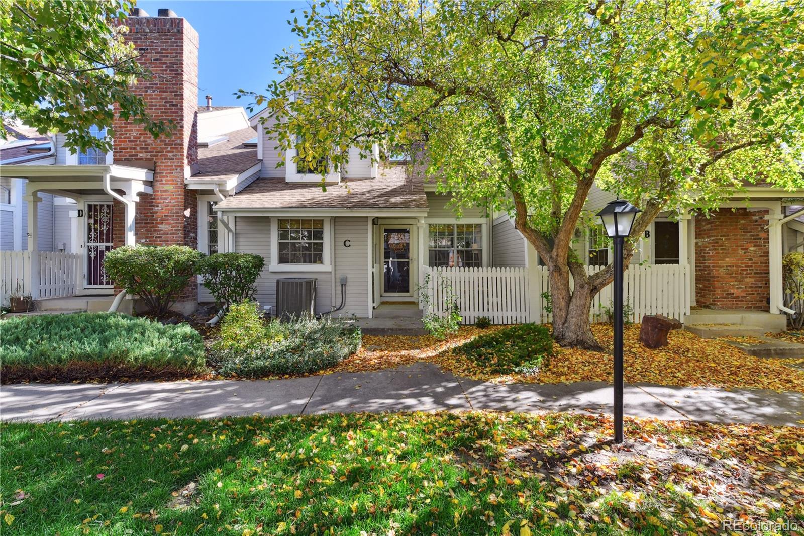 a view of a house with a yard and large tree