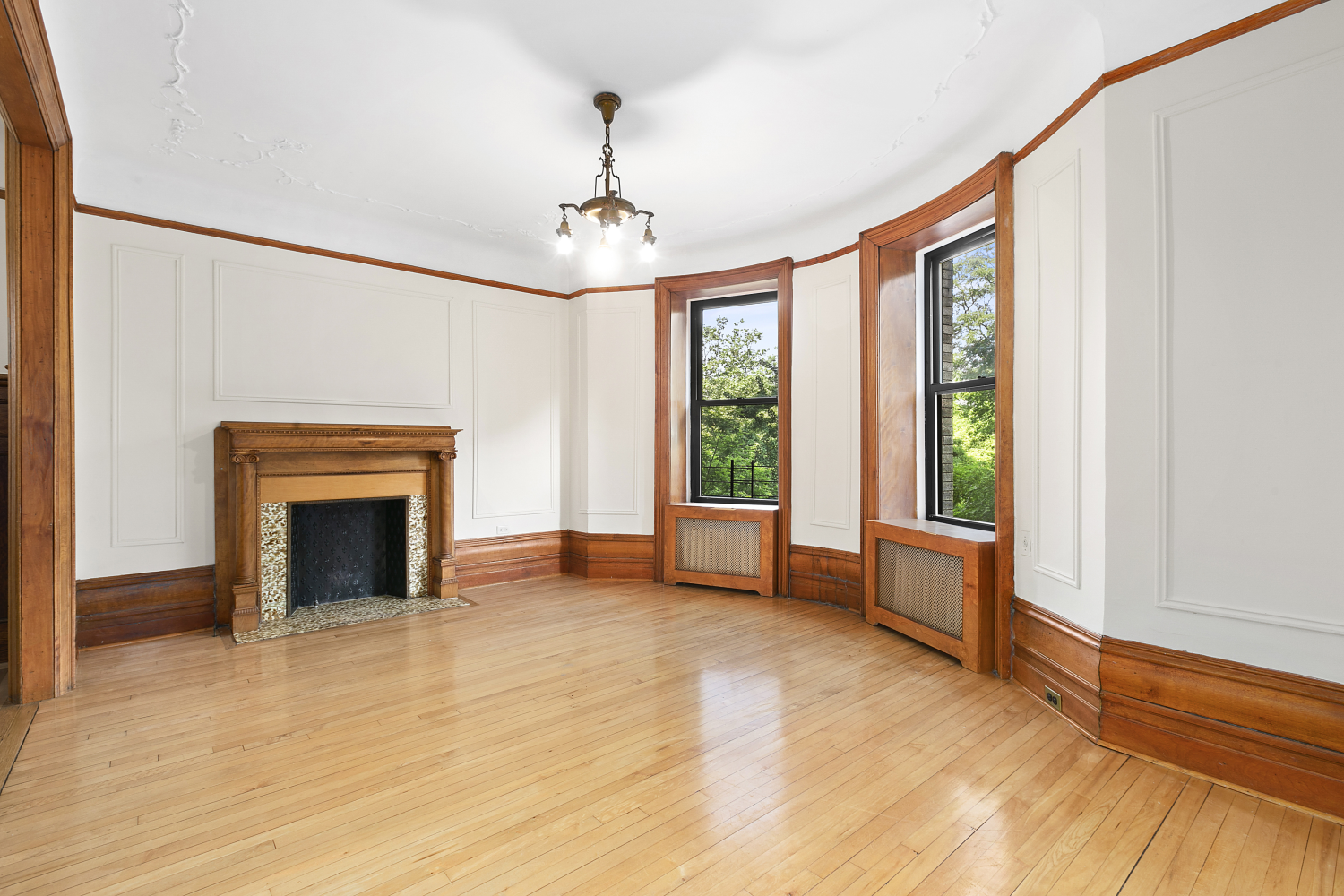 a view of an empty room with glass door and wooden floor