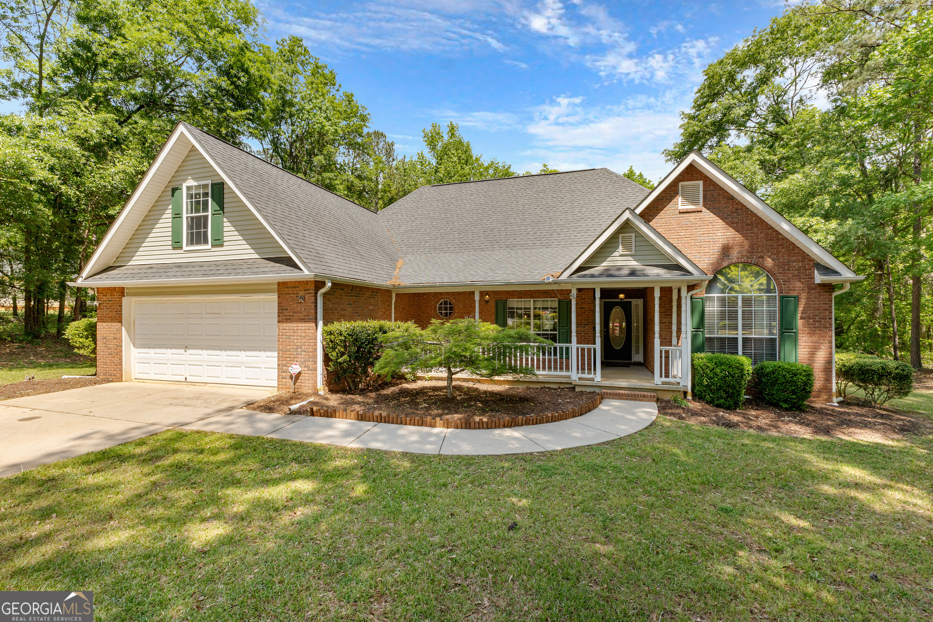 a front view of a house with a yard outdoor seating and garage