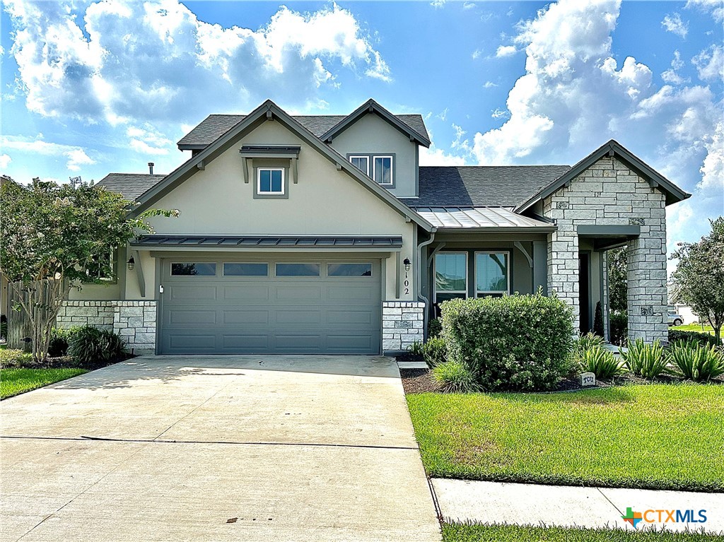 a front view of a house with a garden and plants