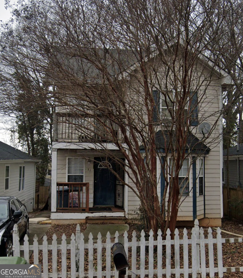 a view of a house with a small yard and a large tree