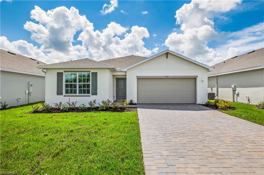 Ranch-style home with a front yard, central AC, and a garage