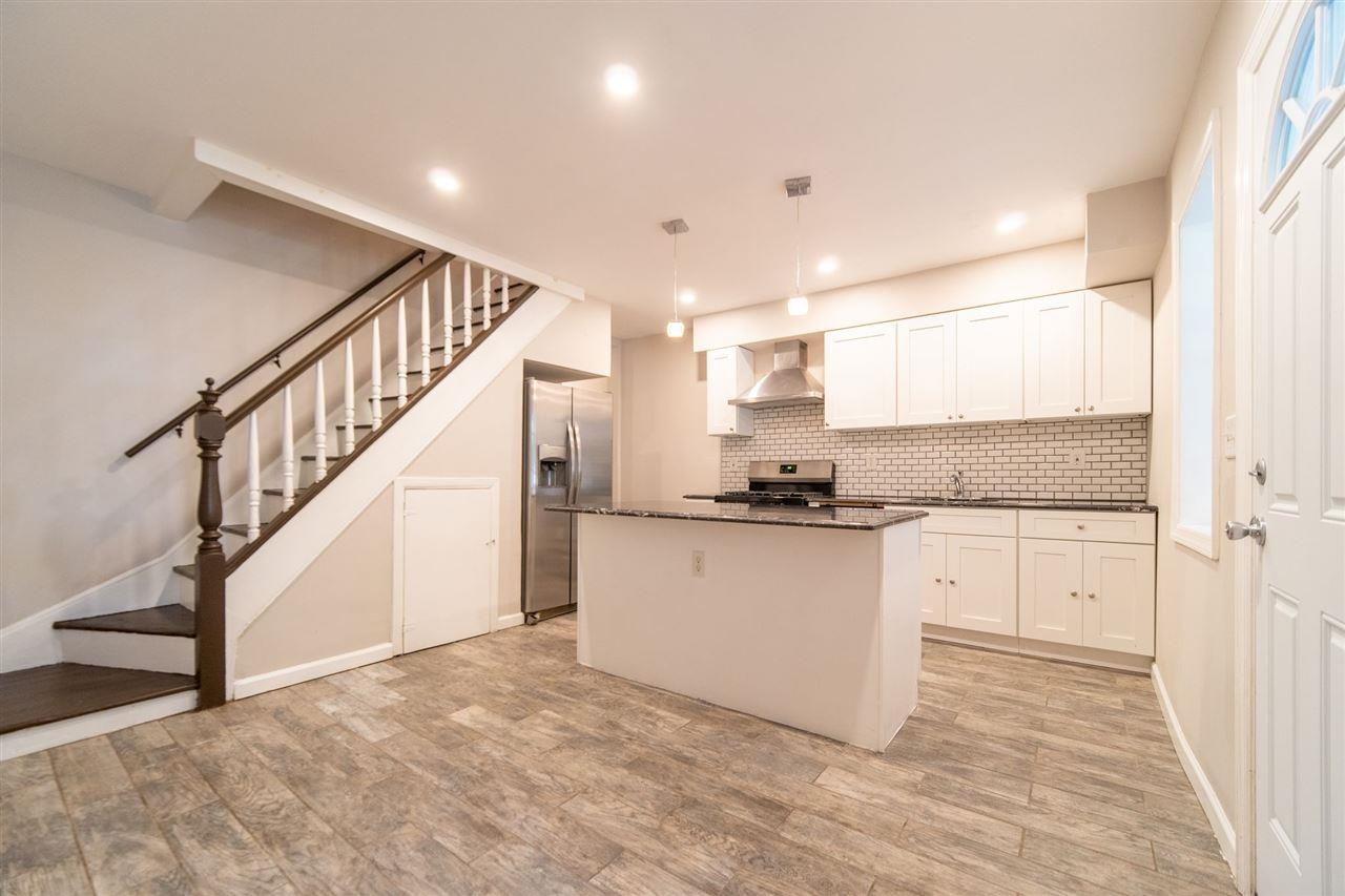 a kitchen with granite countertop white cabinets and white appliances