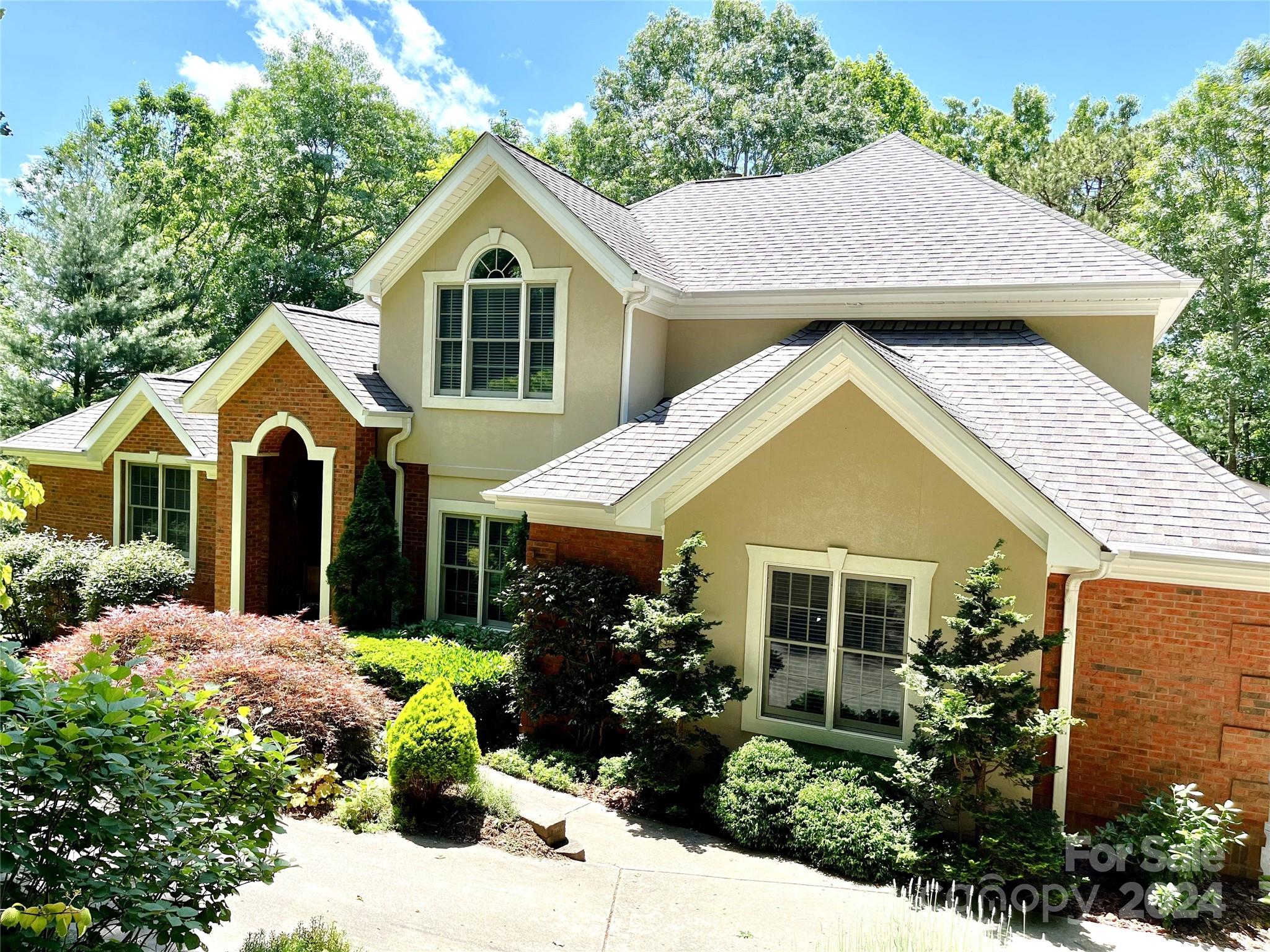 a view of a house with a yard and potted plants