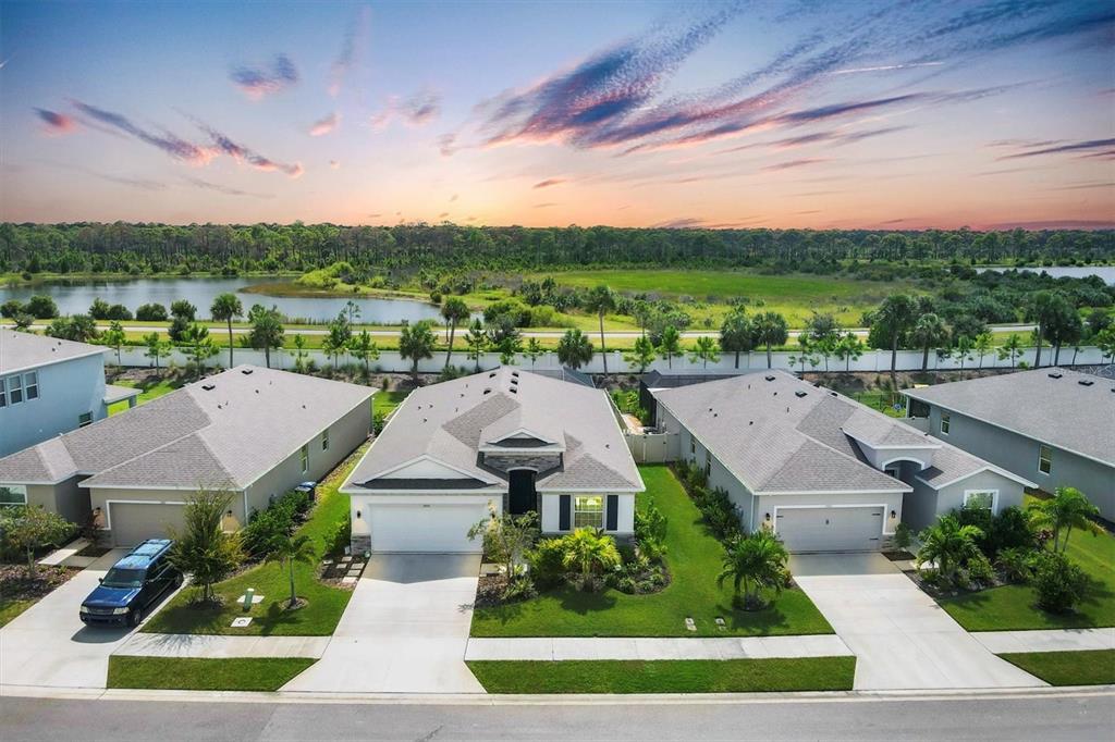 an aerial view of residential houses with outdoor space and trees