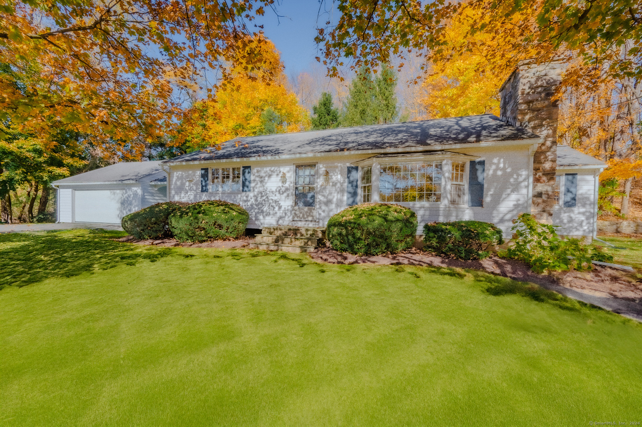 a view of a house with a big yard plants and large trees