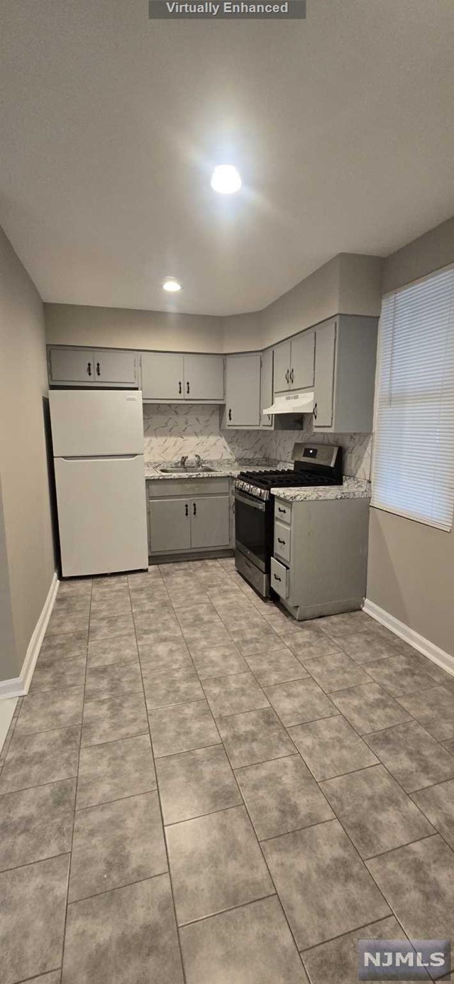 a kitchen with a stove top oven and cabinets