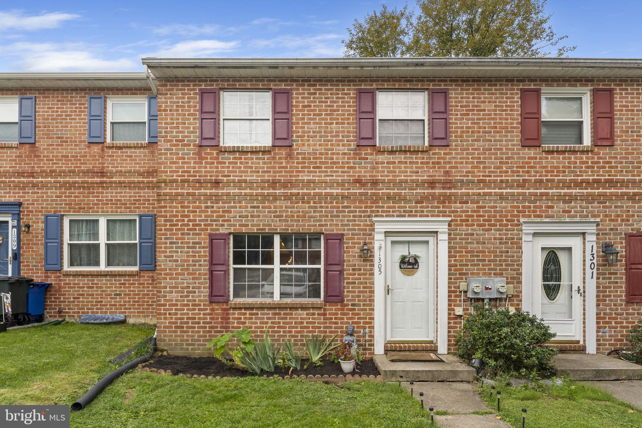 front view of a brick house with a yard