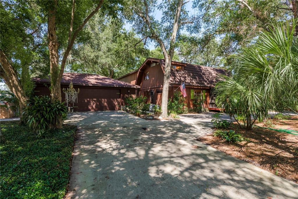 a front view of a house with a yard and tree s