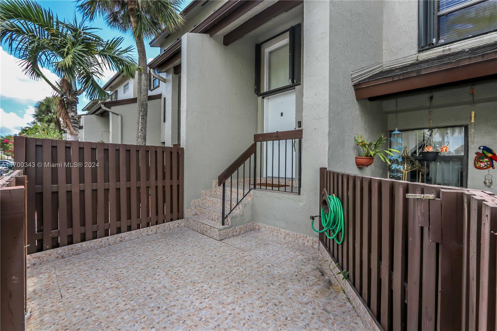 a view of a house with a small yard and potted plants