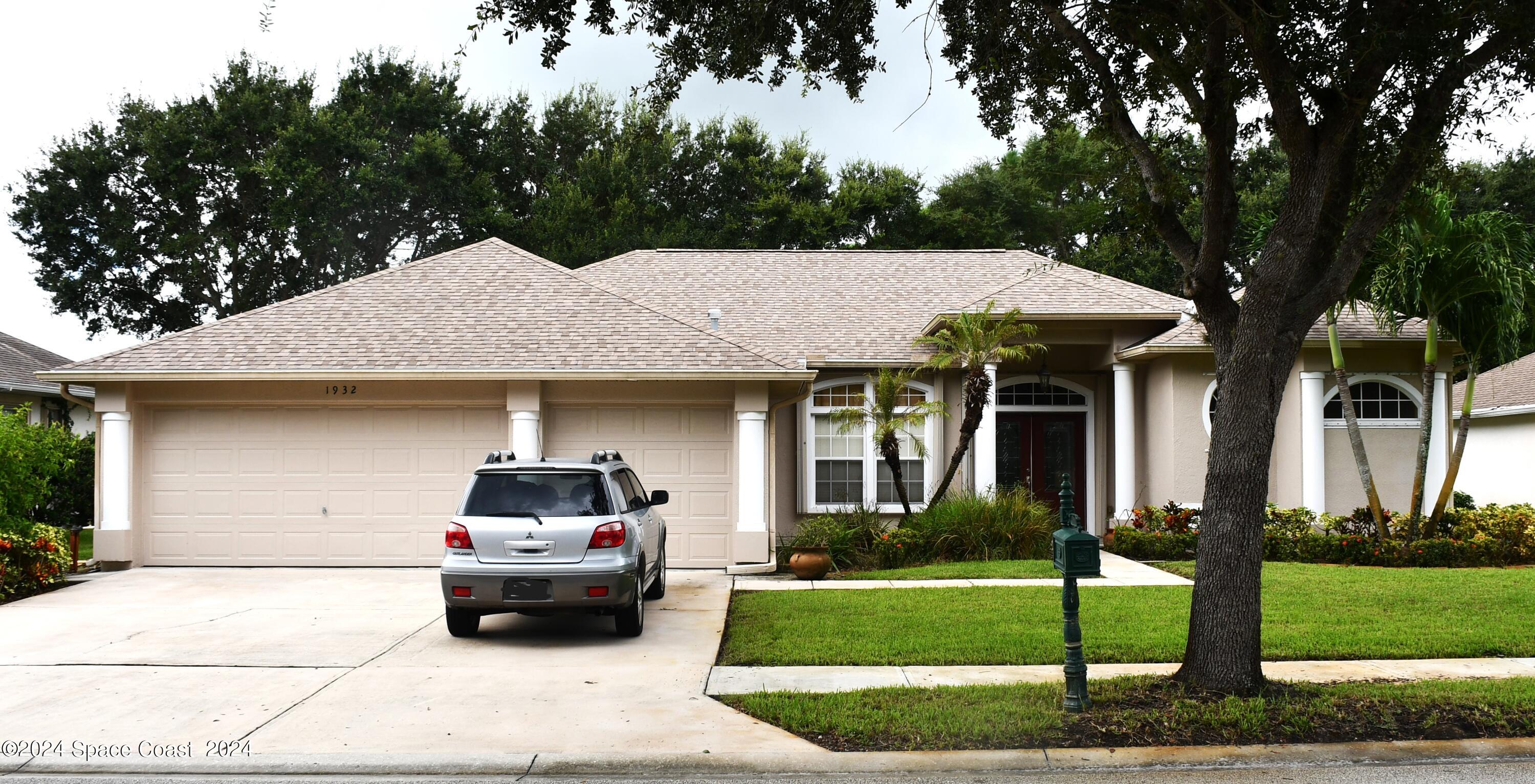 a car parked in front of a house with a yard