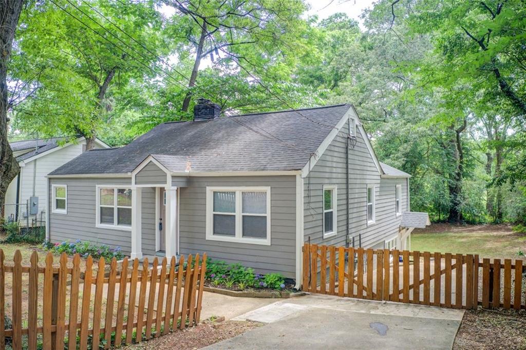 a view of a house with a small yard and wooden fence