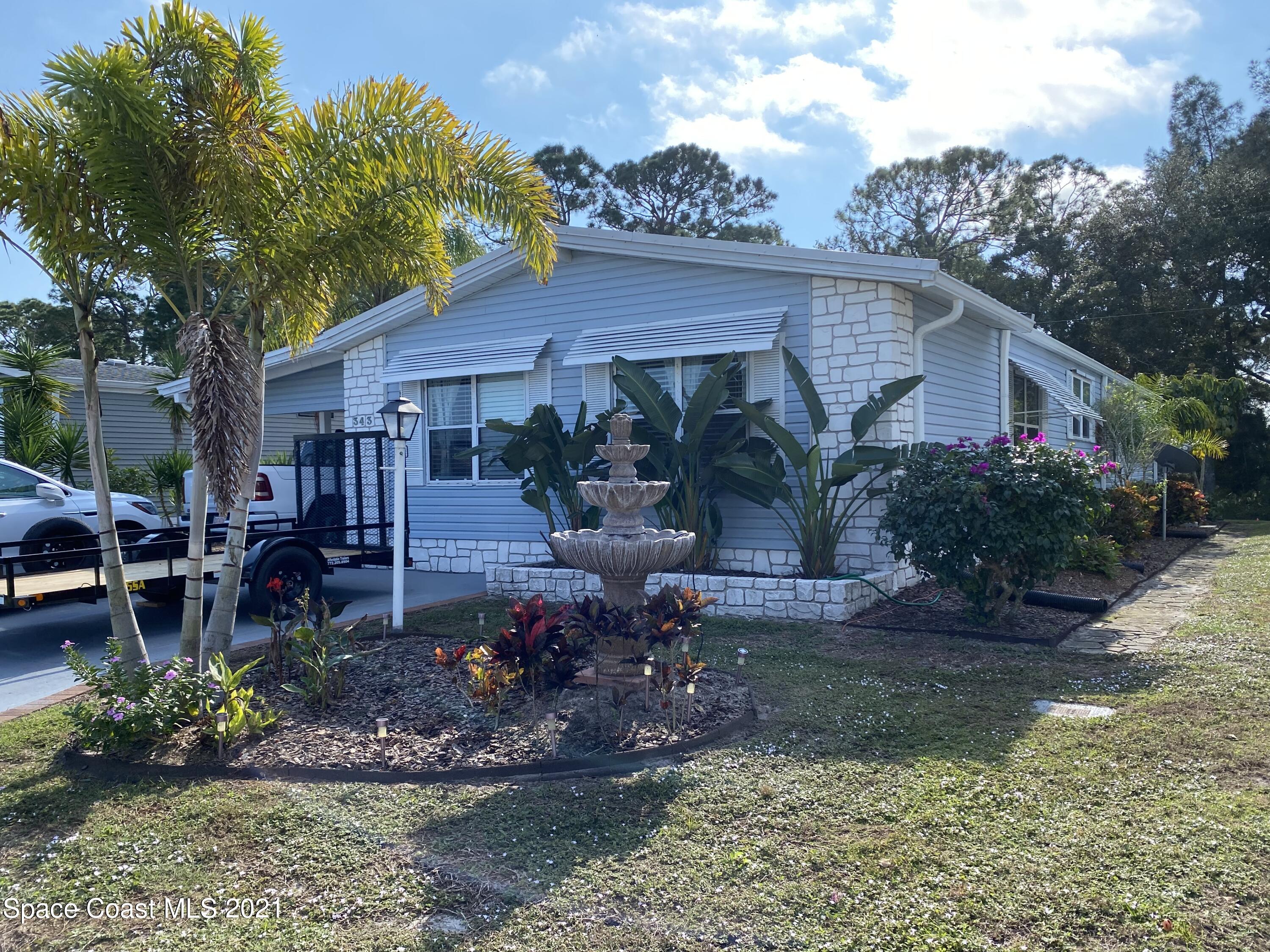 a view of a house with backyard garden and plants