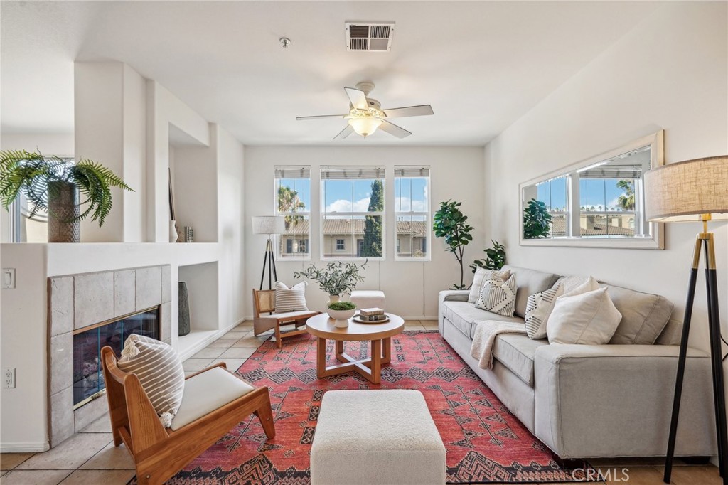 a living room with furniture a fireplace and a potted plant