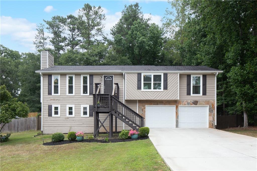 a front view of a house with a yard and trees