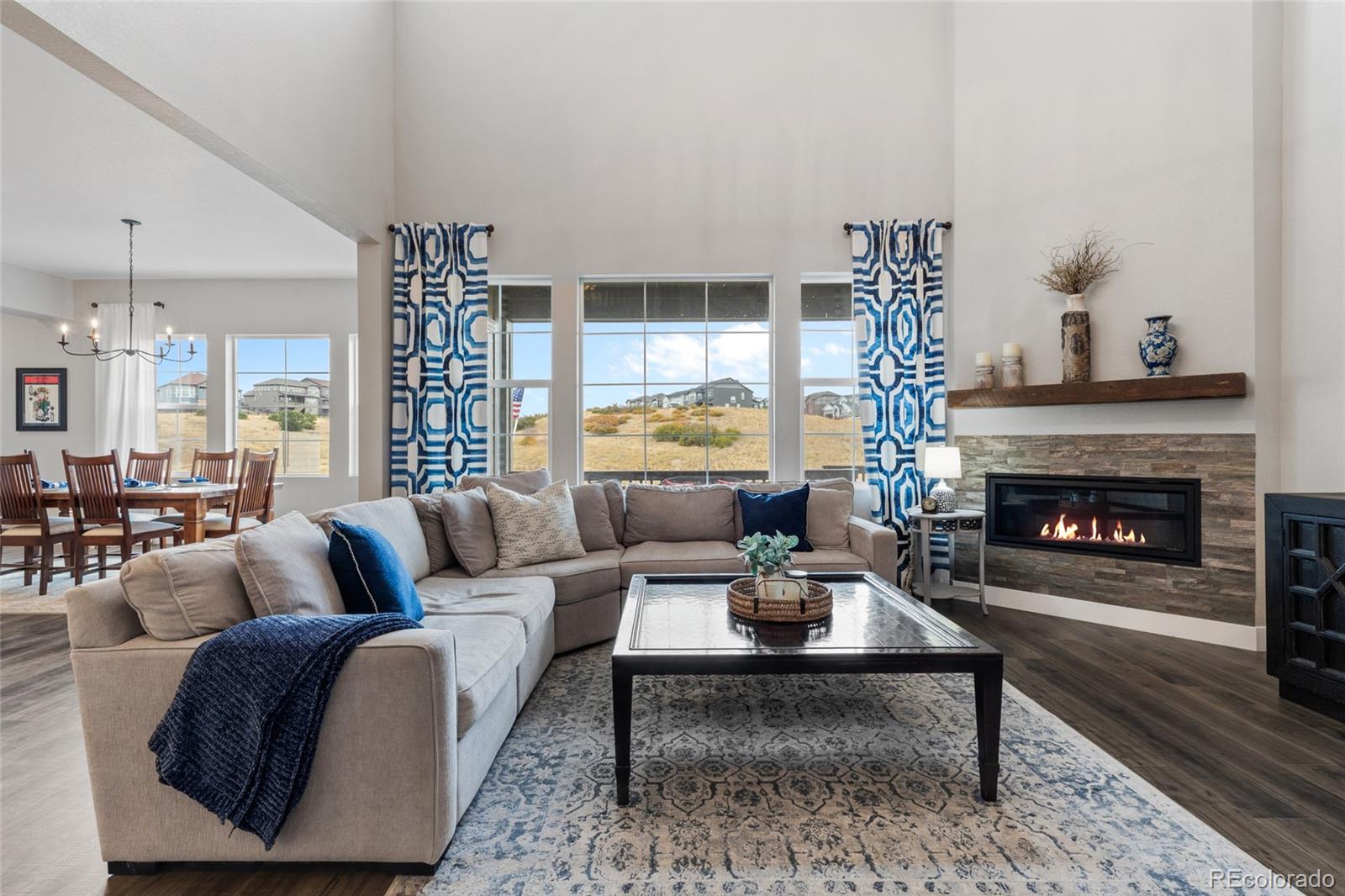 a living room with furniture a large window and a fireplace