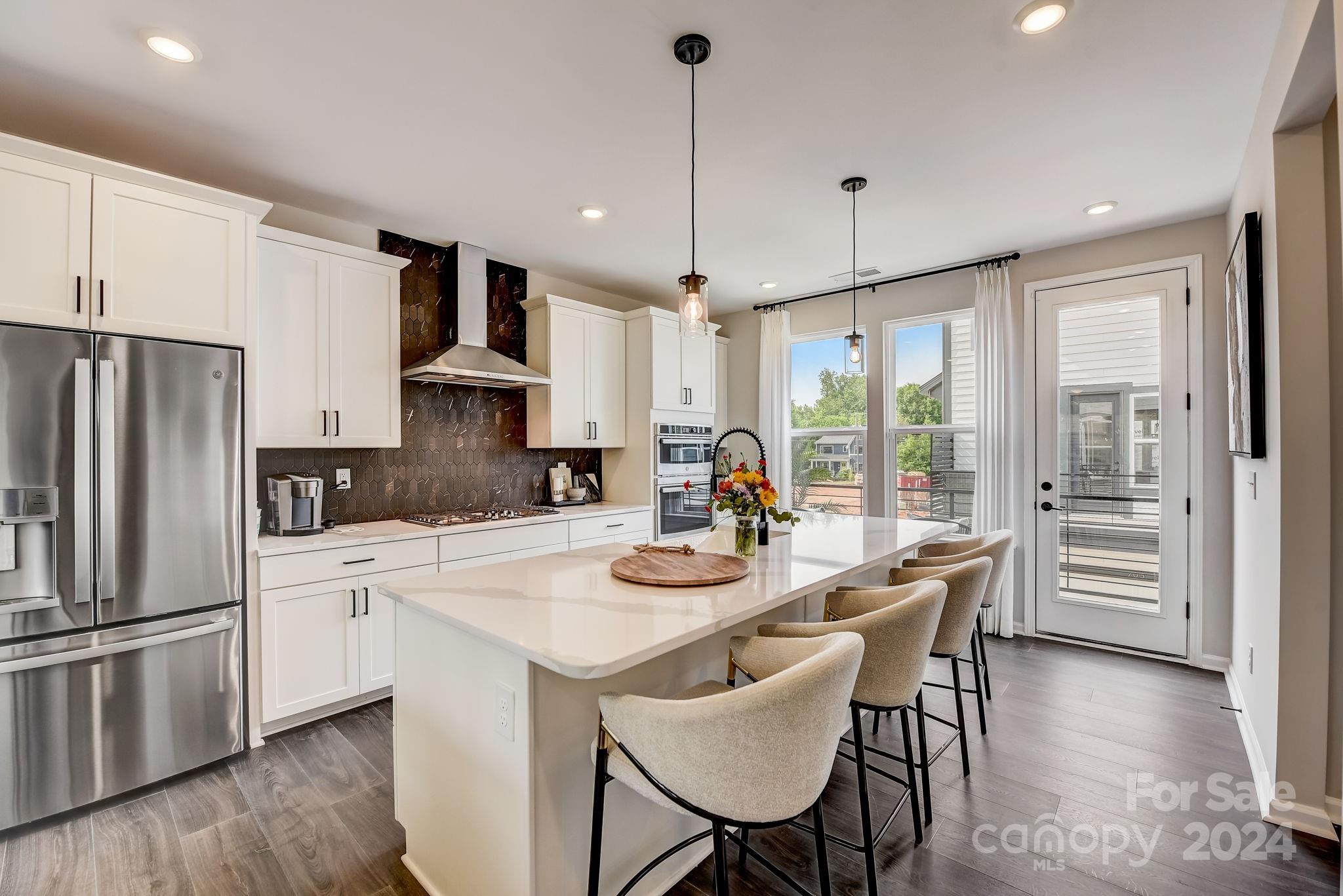 a kitchen with refrigerator cabinets dining table and chairs