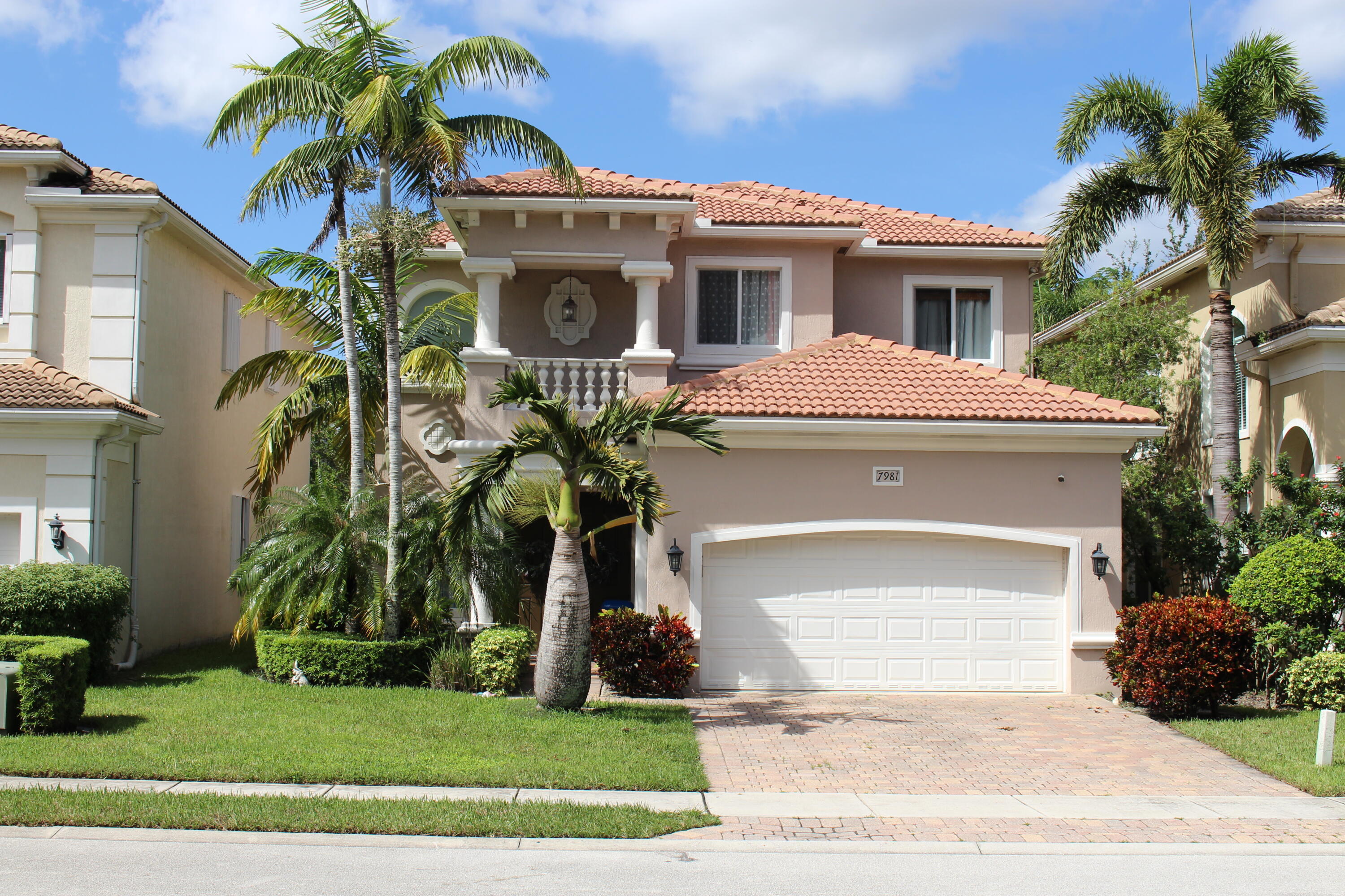 a front view of a house with a yard and potted plants