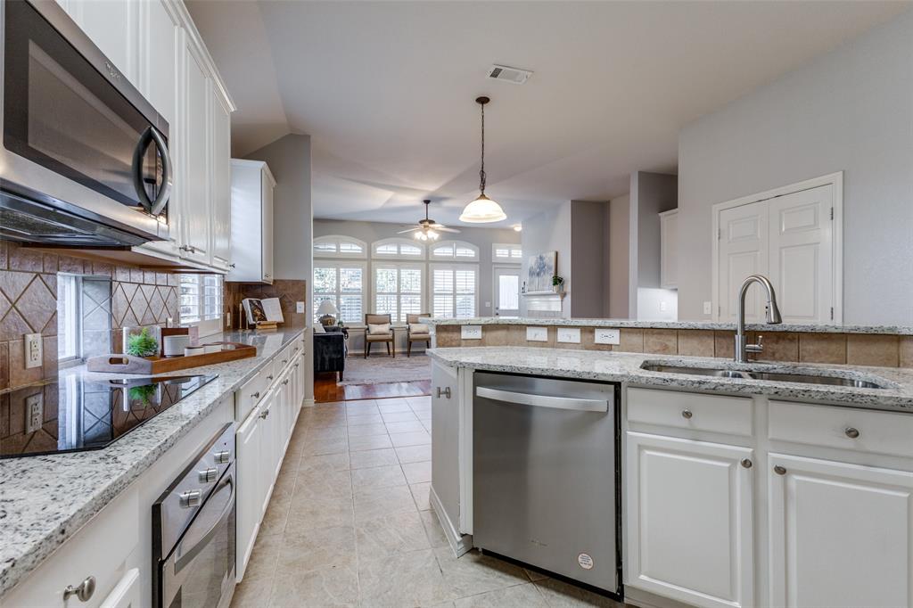 a kitchen with kitchen island granite countertop a sink a counter top space appliances and cabinets