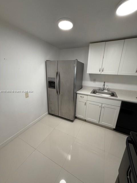 a kitchen with a sink a refrigerator and cabinets