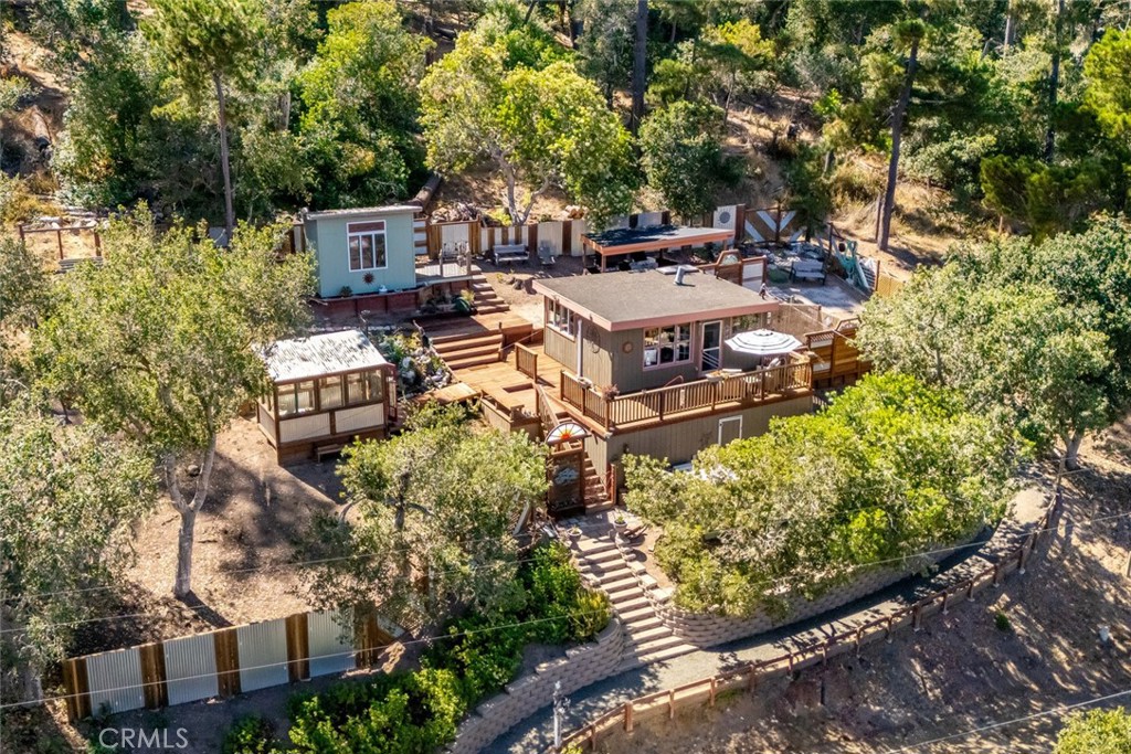 an aerial view of a house with swimming pool and large trees