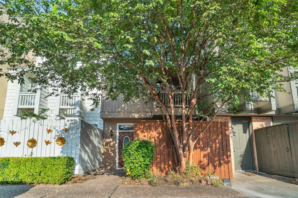 a front view of a house with a tree