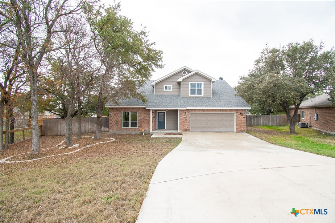 a front view of a house with a yard and trees