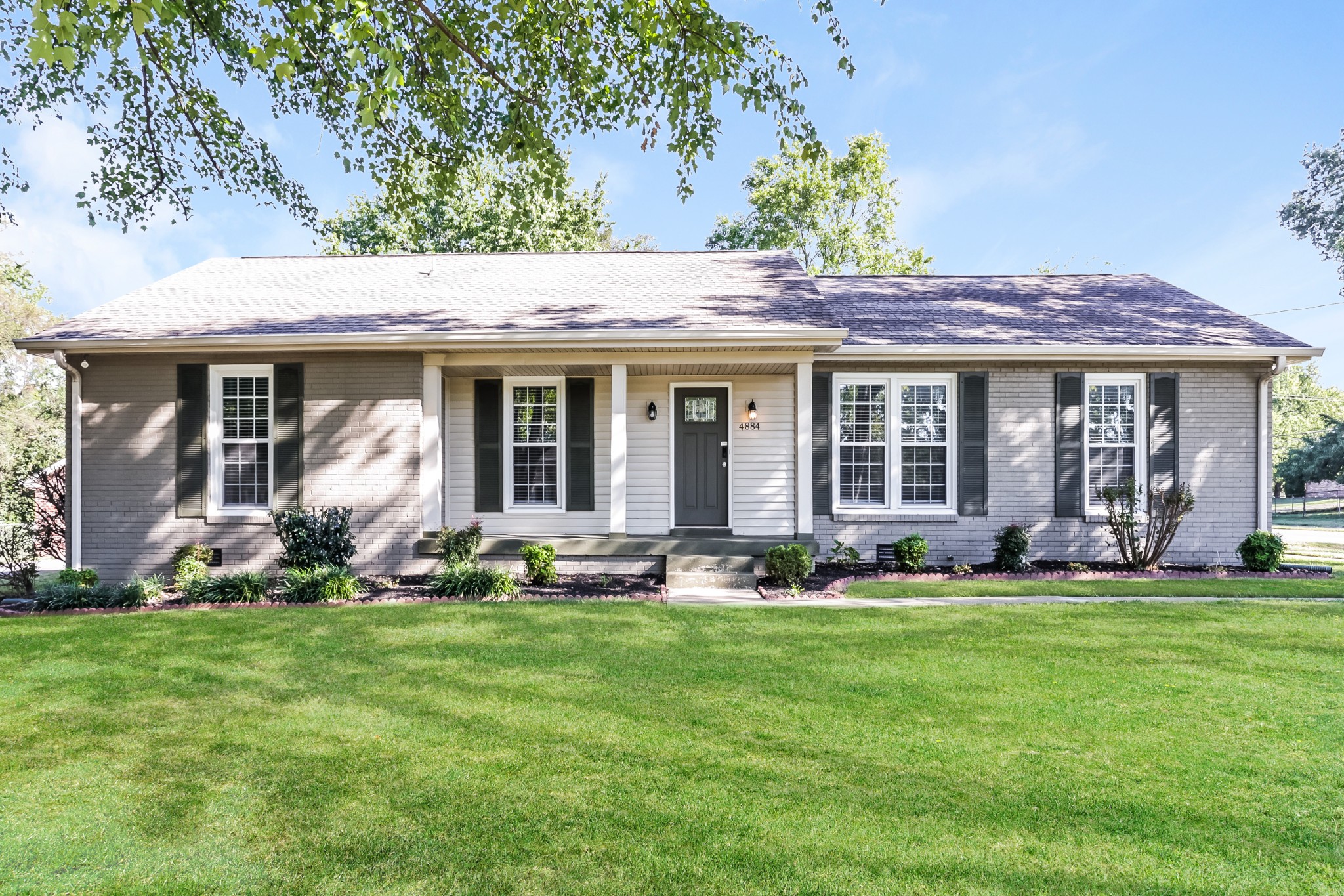 a front view of a house with a yard and porch