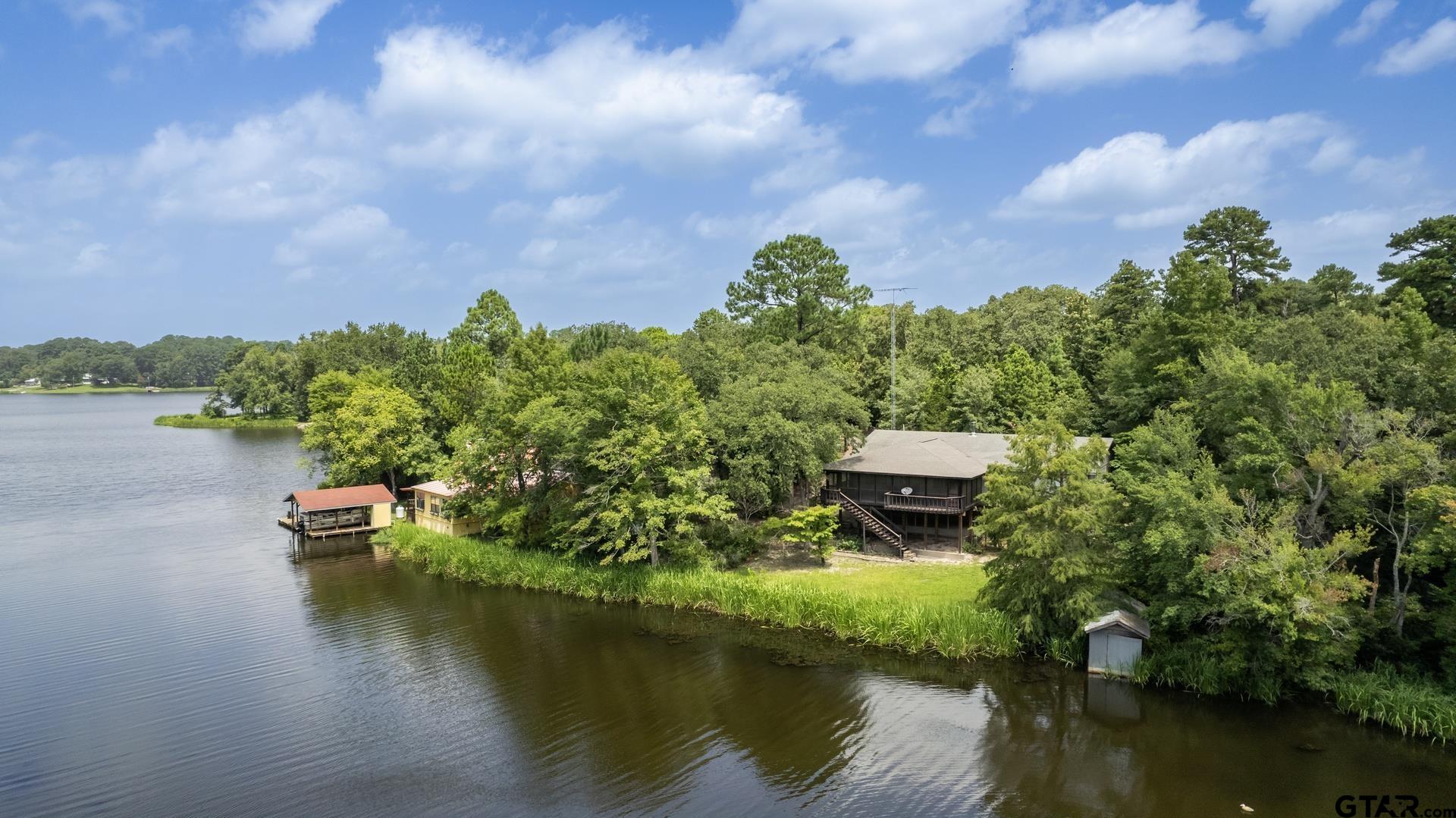 a aerial view of a house with a yard and lake view