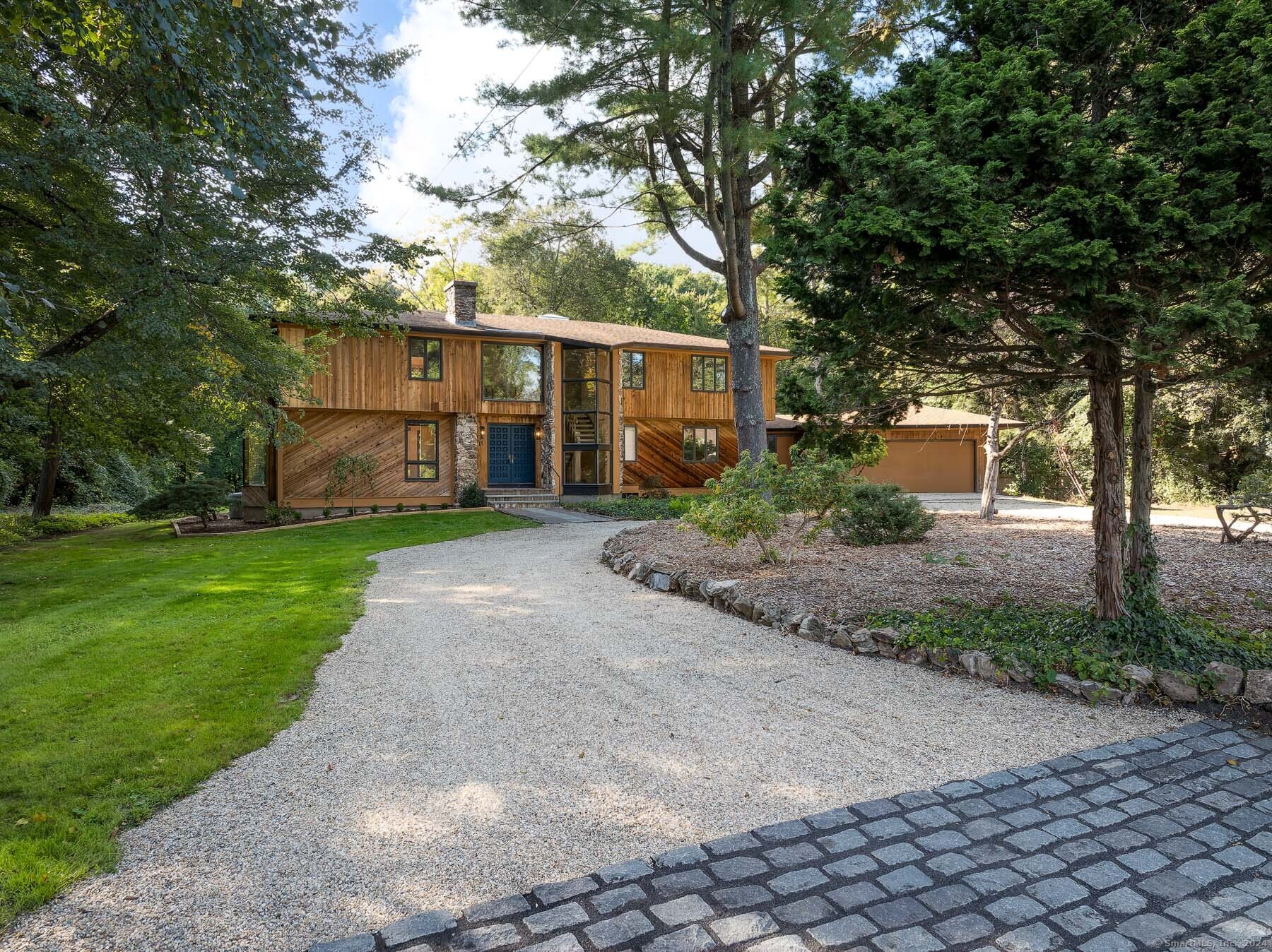 Exterior front with new pebble driveway and cobblestone apron