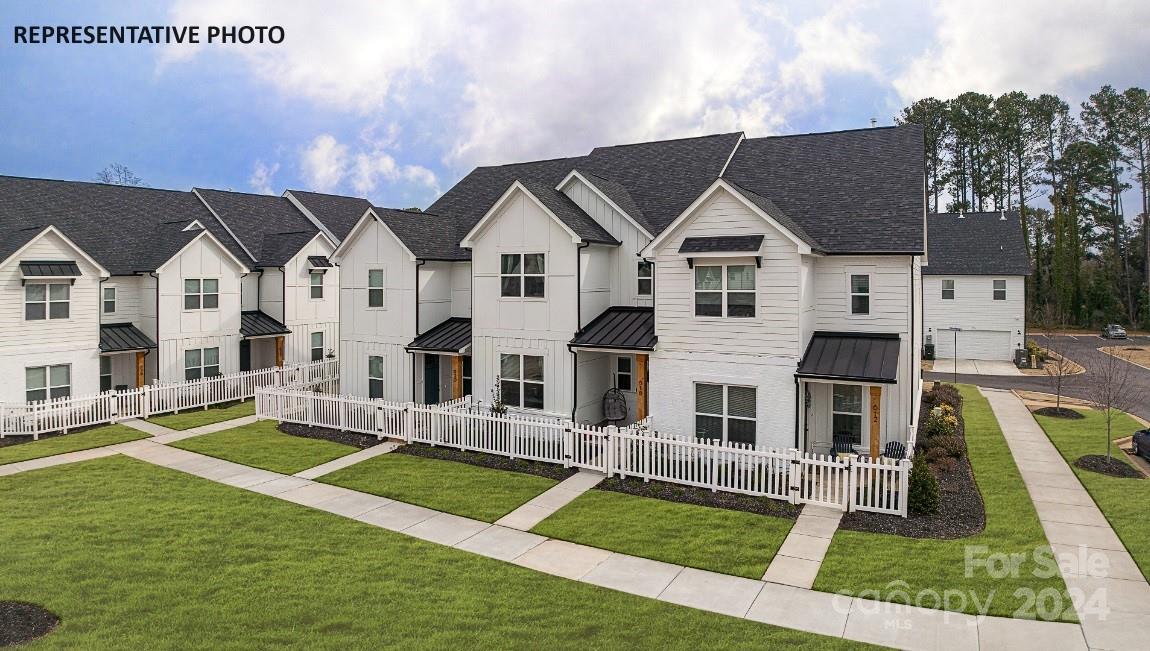 a front view of residential houses with yard and green space