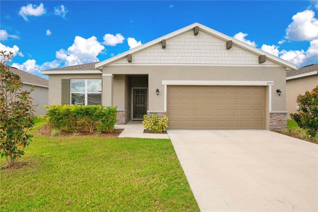 a front view of a house with a yard and garage