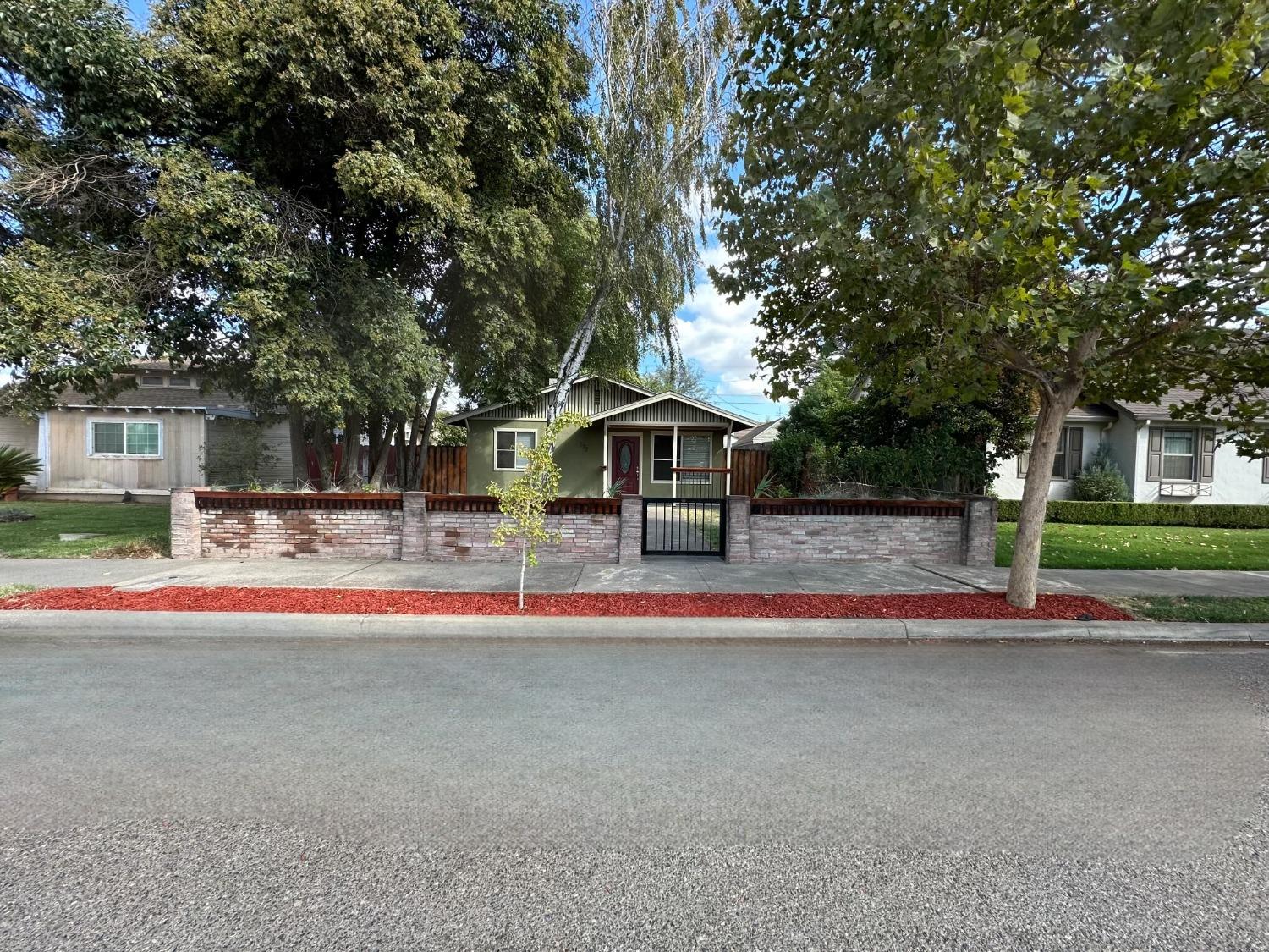 a front view of a house with a yard and trees