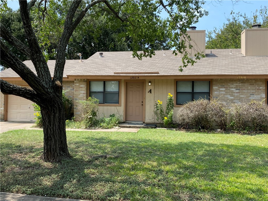 a front view of a house with yard and green space