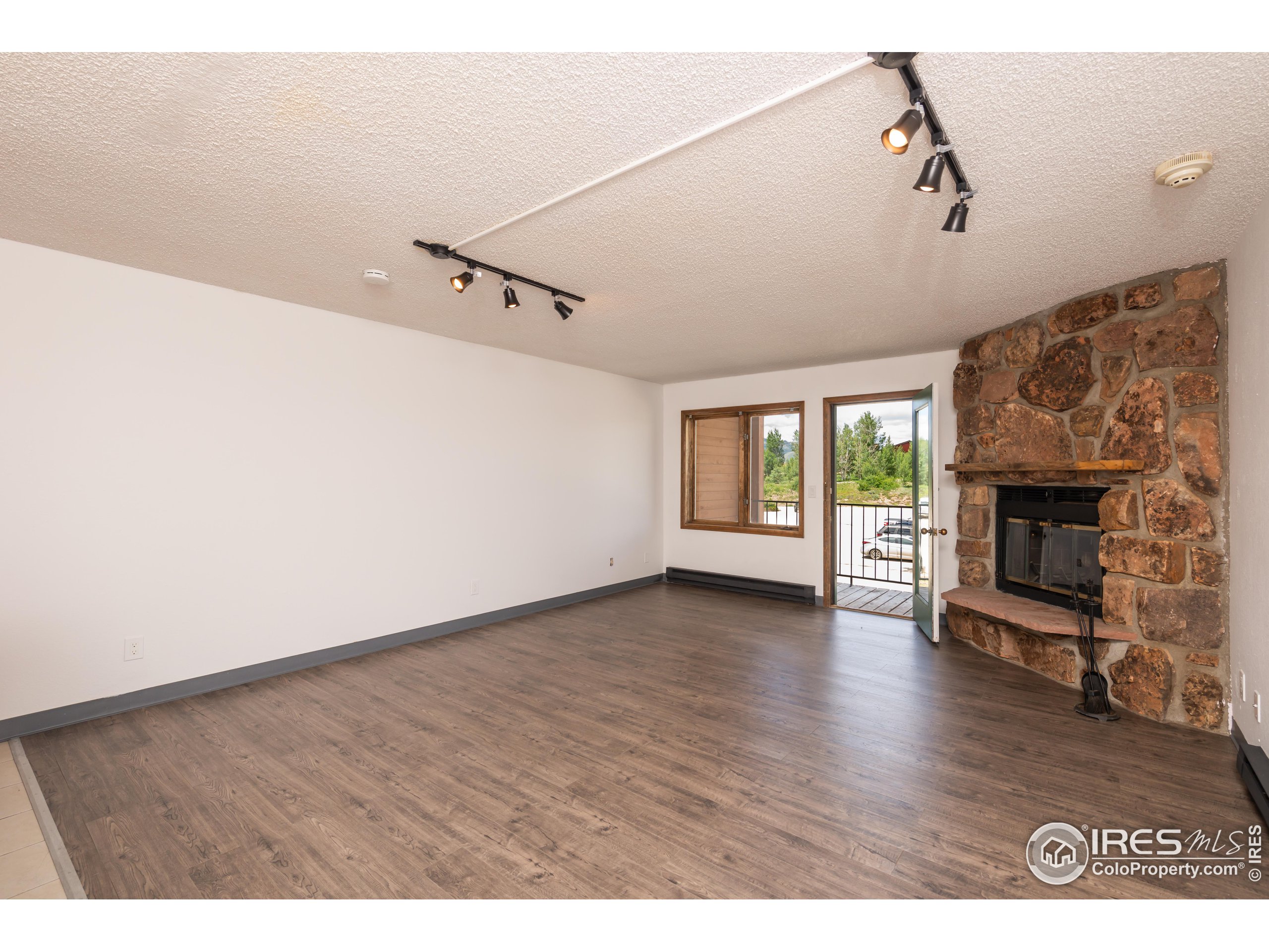 a view of empty room with wooden floor and fireplace