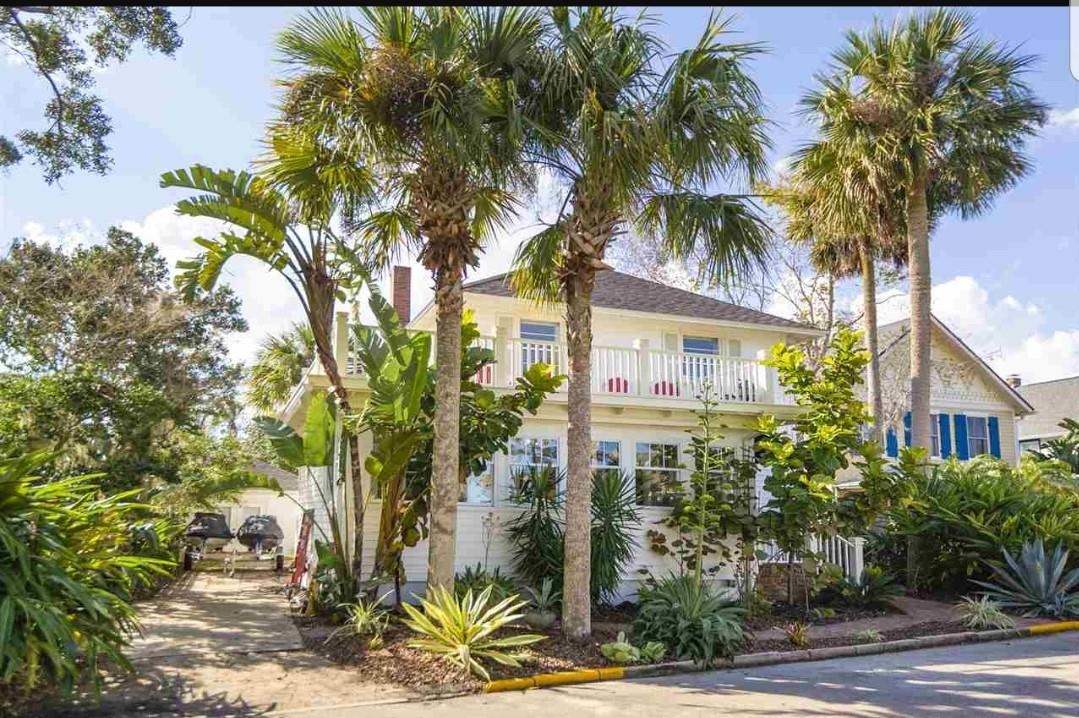 a front view of a house with a tree