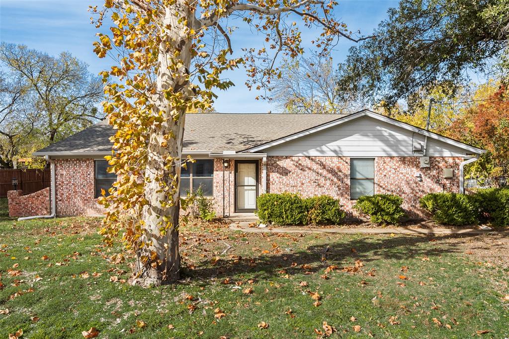 a view of a house with a tree in front of it