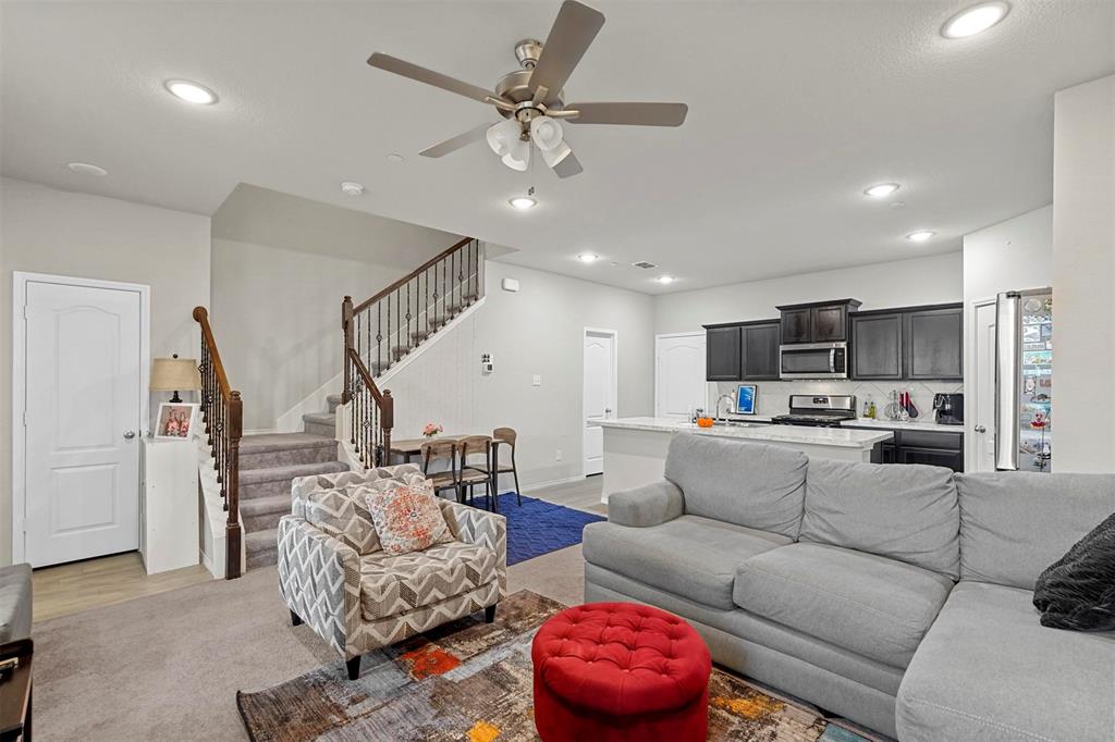 a living room with furniture kitchen view and a chandelier