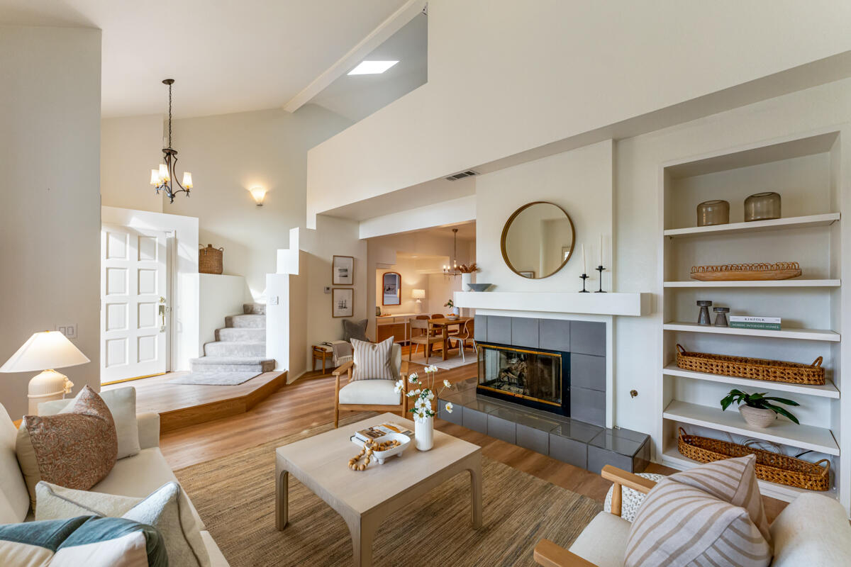 a living room with furniture a fireplace and a large window